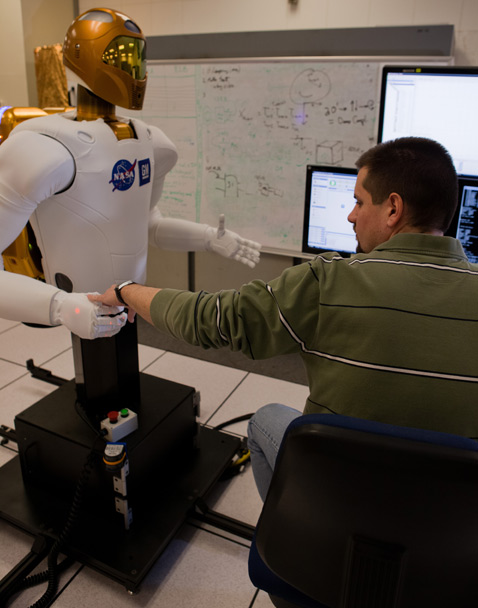 Крис Ирке (Chris Ihrke),
инженер GM, работает над "Робонавтом-2" в центре Джонсона (фото NASA).