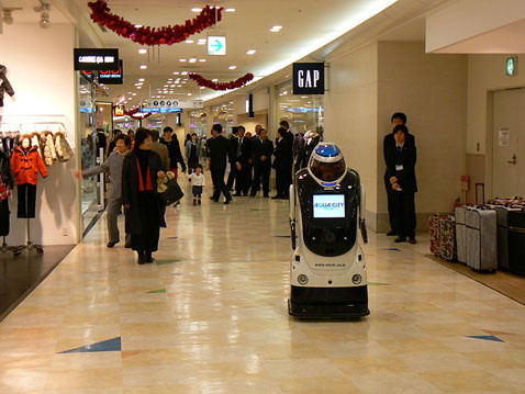 Люди, пришедшие за покупками в торговый центр Aqua City, не проявляют к роботу особого интереса. Оно и понятно — японцы видали и не такое (фото Robot Watch).